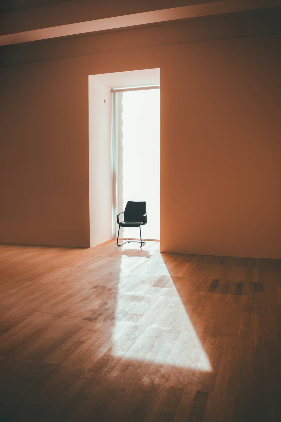 陽の差す戸口のそばに置かれた、座る人のいない椅子